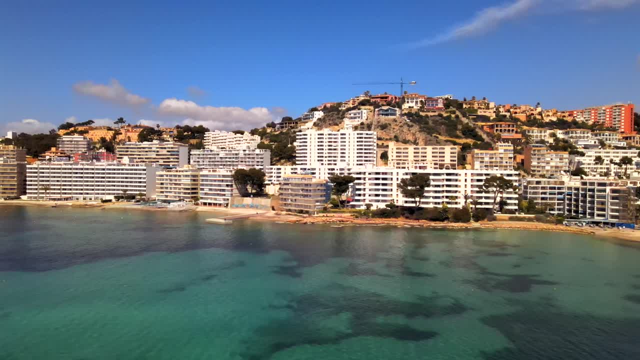 Discover the picturesque Santa Ponsa in Mallorca, featuring vibrant buildings along the shoreline and tranquil blue waters. This location offers a perfect escape for relaxation and adventure.