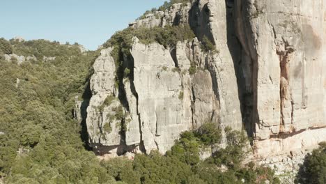 drone approaching towards rock climber hanging on a cliff