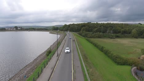 conduciendo un coche a lo largo del lago en el campo en inglaterra