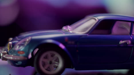 close-up of a blue vintage model car with purple bokeh