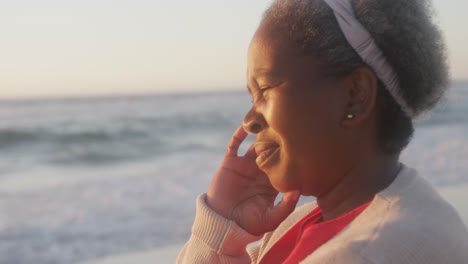 happy senior african american woman smiling at beach, in slow motion