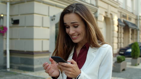 surprised businesswoman using mobile phone outdoors. excited business woman