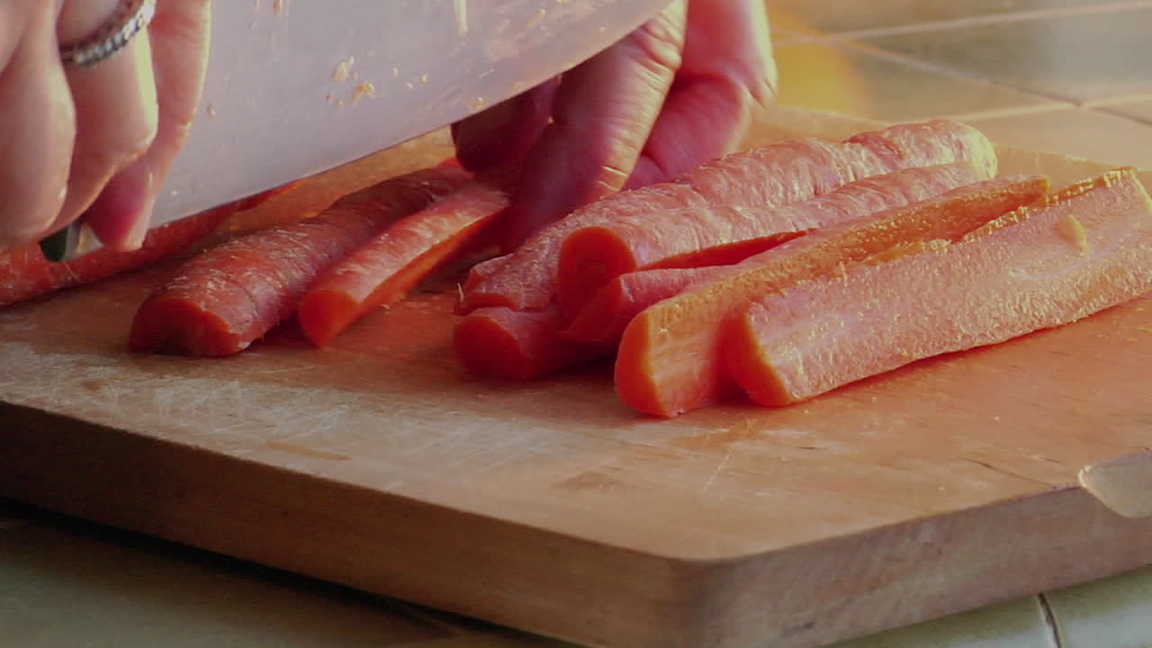 A chef slices carrots with a knife 1
