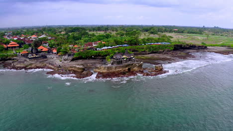 antiguo templo hindú de tanah lot en la costa rocosa de bali con olas marinas