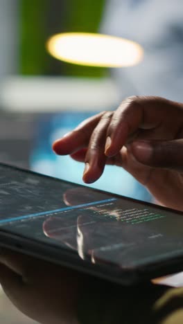vertical video close up of engineer using tablet to write code, developing machine learning api