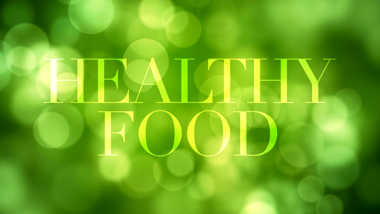 '건강한 음식' 텍스트가 나타나고 잠시 후에 녹색 반이는 불빛으로 녹색 보케 배경에 반사되는 불명확한 빛이 사라집니다. 건강한 삶, 봄, 숲 개념 비디오