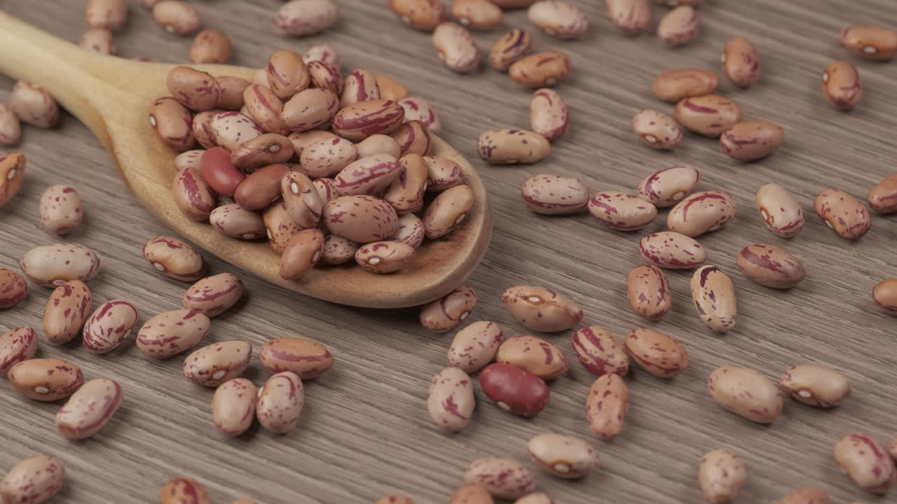 Dry red beans on wooden spoon, vegan vegetarian protein source rotating, Mediterranean healthy diet