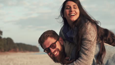 una pareja feliz en un paseo a caballo en la playa