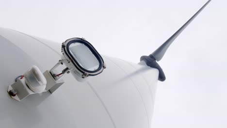 low angle shot of a spotlight fixed to a wind turbine turning its blades