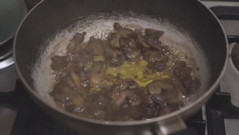 fotografía de cerca de setas cocidas en una sartén con salsa teriyaki