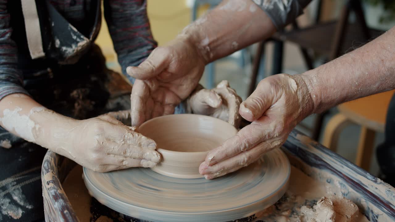 남자 와 소년 의 손 이 던지는 바 에 회전 하는 도자기 그 을 들고 있는 시네마그래프 루프