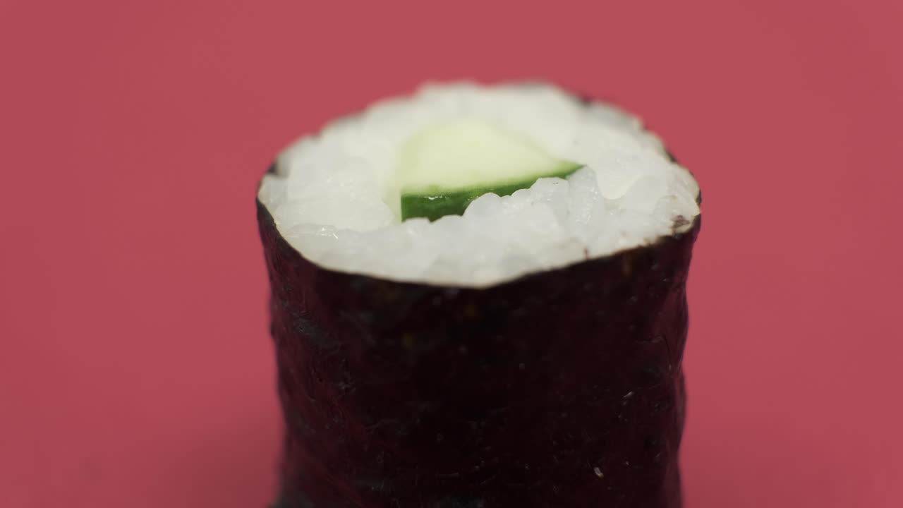 un rollo de sushi girando sobre un fondo rojo