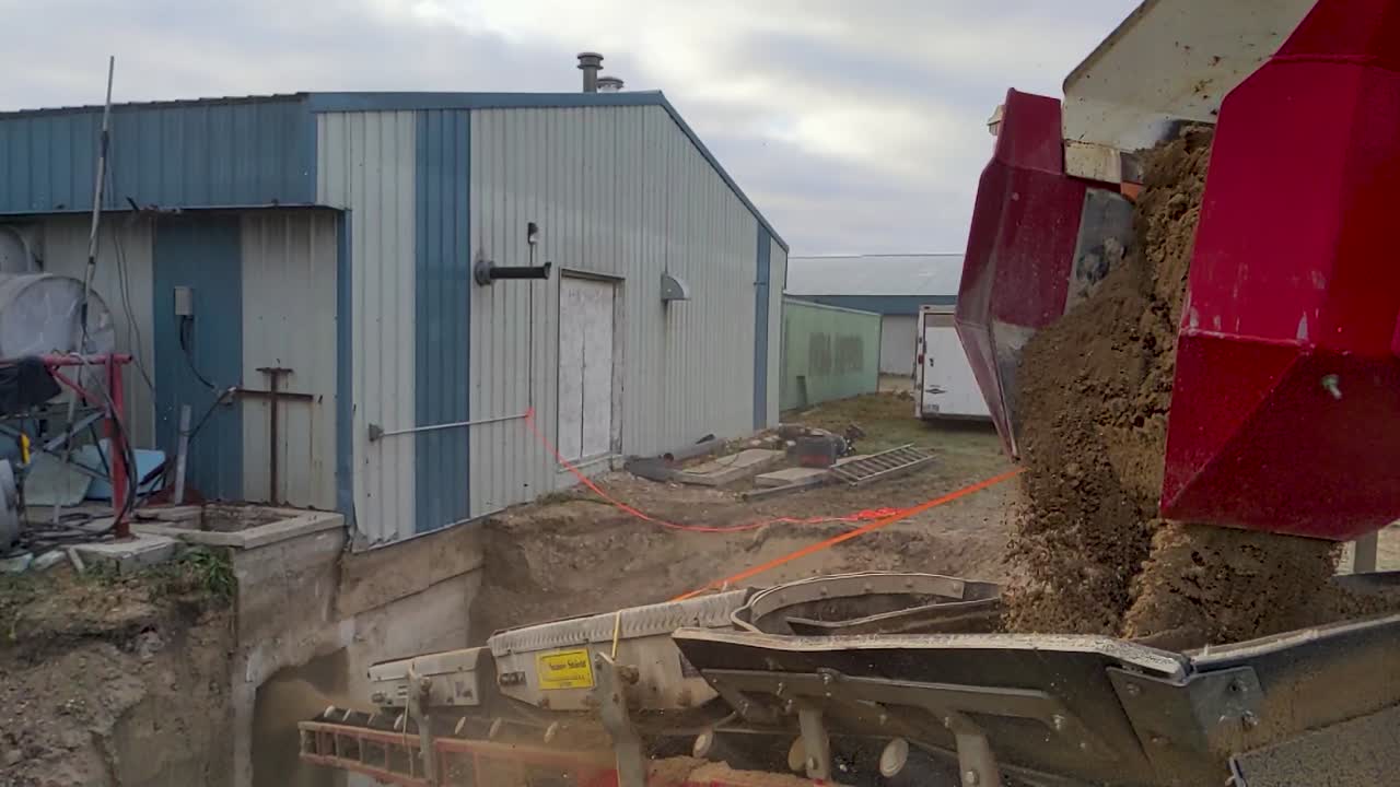 SLO MO Gravel being unloaded from a piece of specialized equipment at the construction site.  Stone slinger thrower. 4k