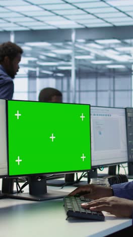 vertical video engineer using green screen computer, working in server farm