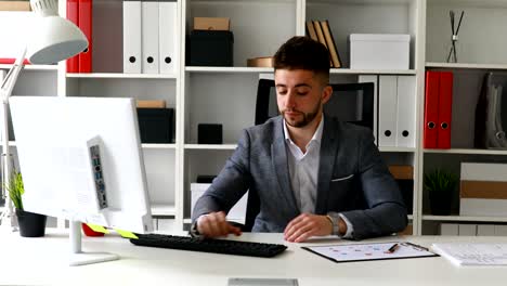 uomo d'affari frustrato in abito che scrive sulla tastiera