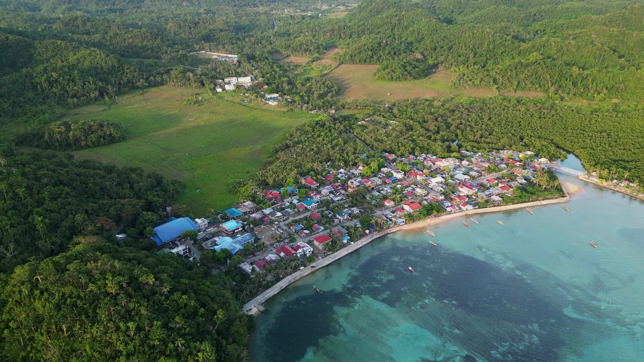 Villaggio vivace lungo la spiaggia della baia a Brgy Magnesia Del Sur e Norte a Virac, Catanduanes, Filippine. Ripresa aerea con drone