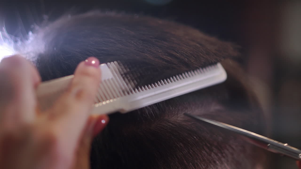 Close up of men's hair cutting scissors in a beauty salon. Frame. Close up of a haircut at a hair saloon. Professional barber styling hair of his client