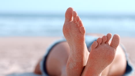 piedi, spiaggia ed estate con una donna sdraiata