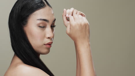 biracial woman with black hair and make up looking at camera, copy space, slow motion