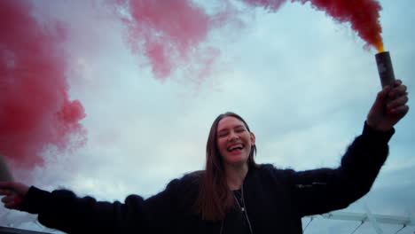 Girl-moving-smoke-bombs-in-hands.-Woman-posing-on-street-in-colorful-smoke