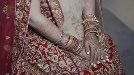 novia india con muchos brazaletes y tatuajes de henna en la ceremonia de matrimonio