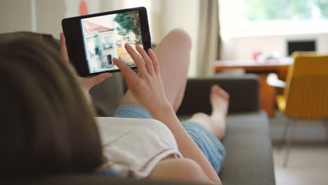 woman relaxing on couch with tablet