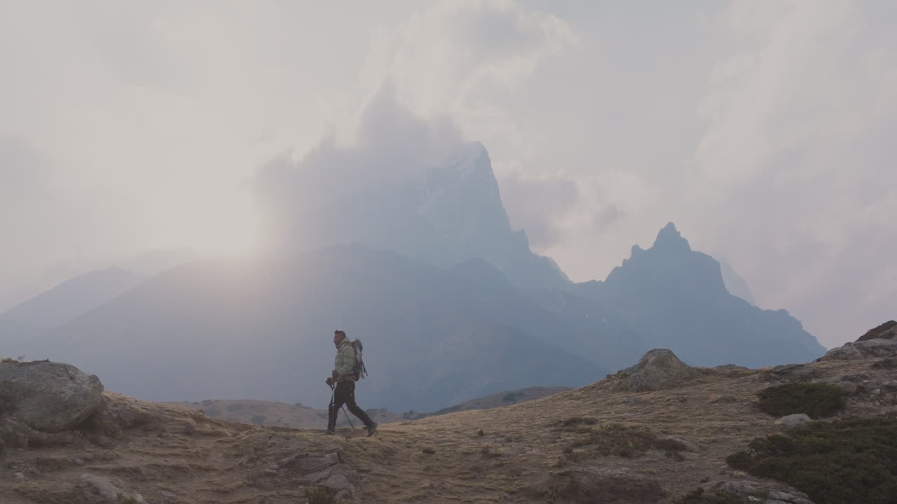 Tourist hikes Dingboche trail to Everest Base Camp in Nepal. Smoky weather, serene trek, stunning village view, alert for nature conservation adventurous travel and tourism