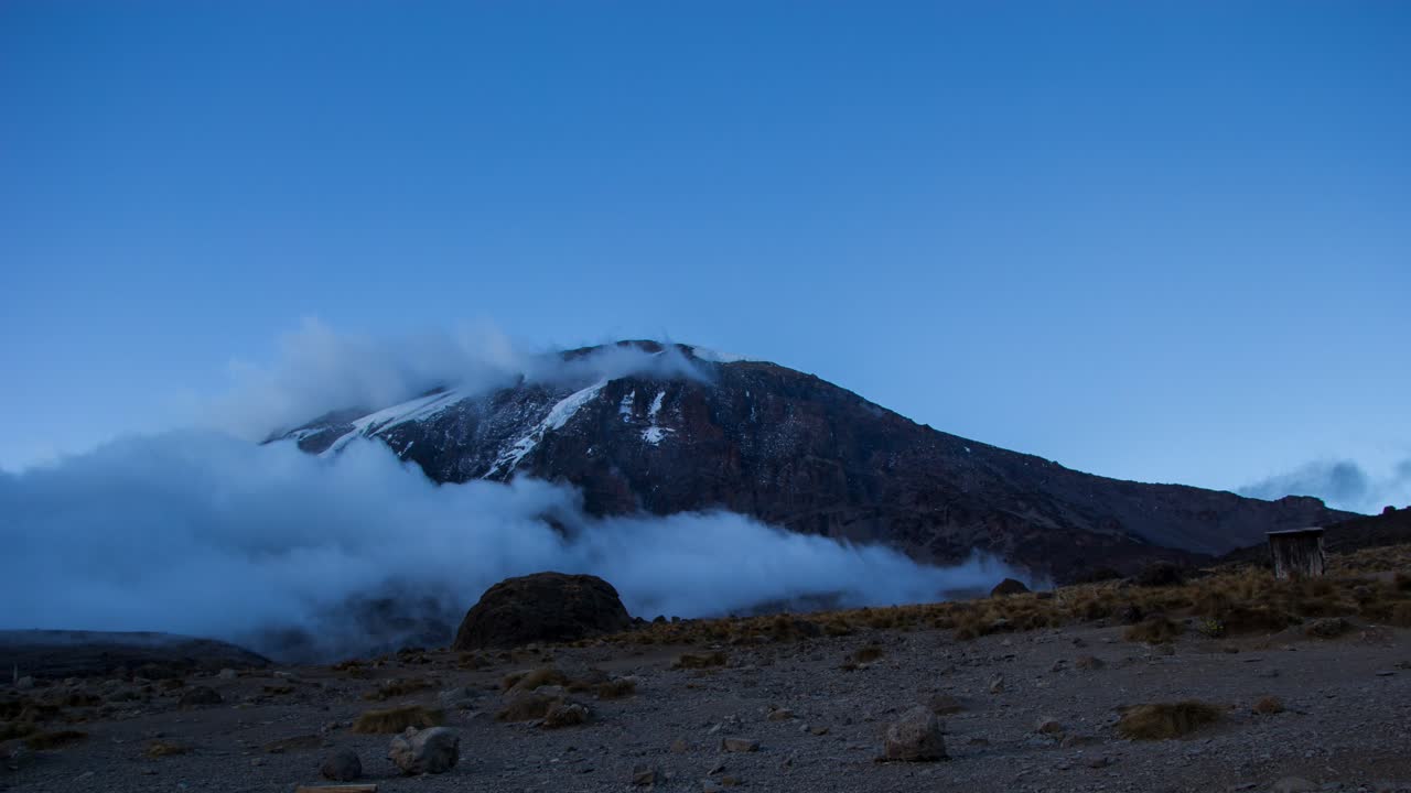 nubes que se forman alrededor de la cumbre del monte kilimanjaro mientras se pone el sol