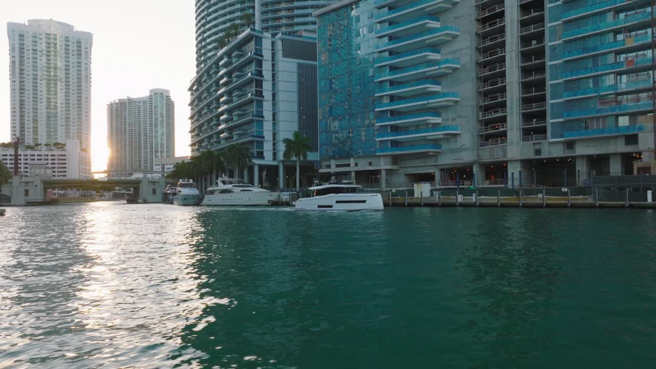 vuelo bajo sobre el agua turquesa cristalina en el río que fluye a través de la ciudad. barco que pasa a lo largo de la costa. miami, ee.uu.