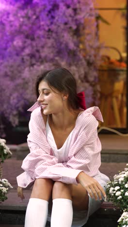 young woman sitting outdoors with flowers