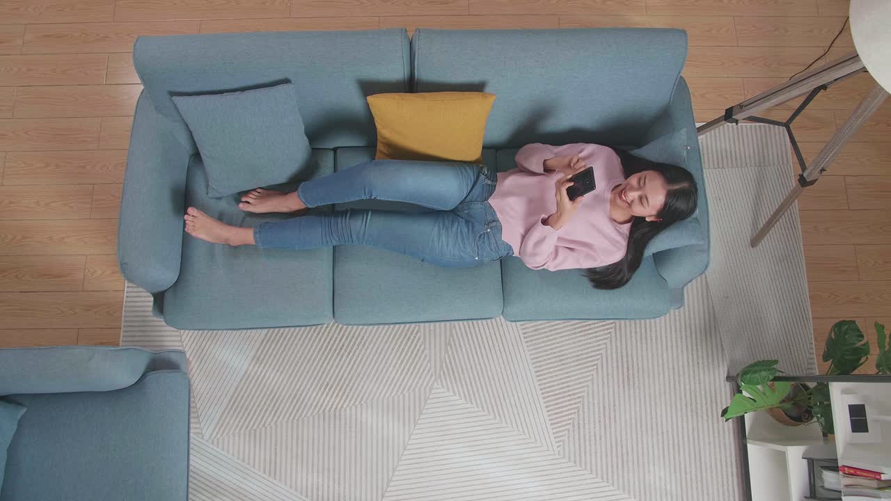 mujer relajándose en el sofá usando el teléfono