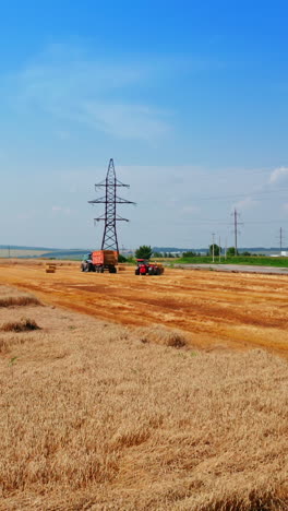 scenic picturesque plantation on summer harvest season. machinery in the field picking the hay bales after mowing the crops. vertical video
