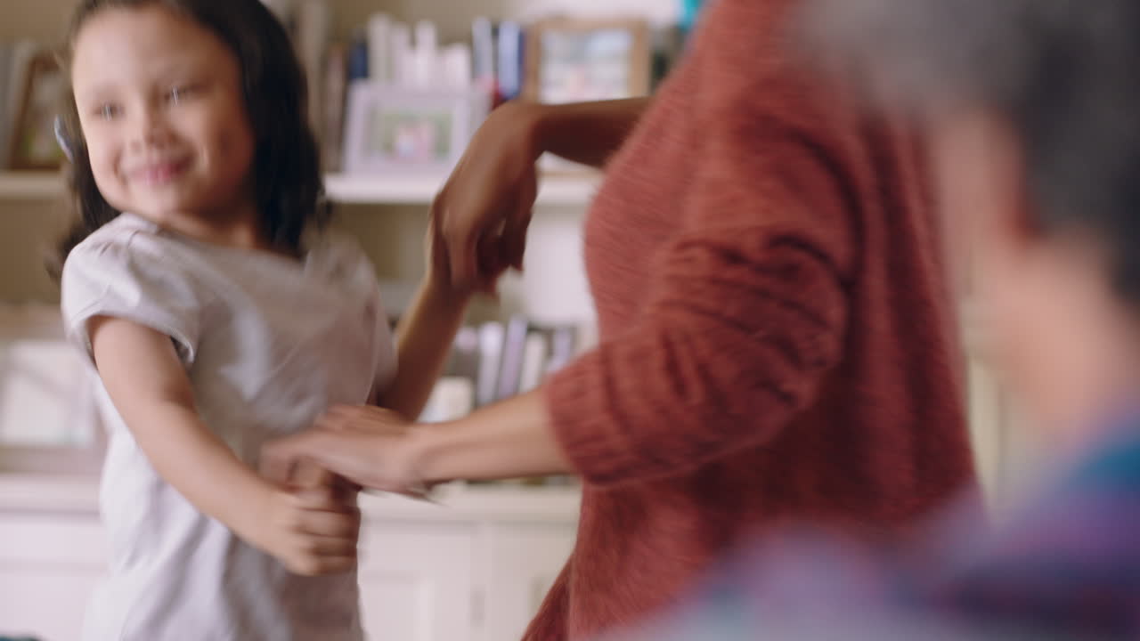 niña linda bailando con su madre en casa familia divirtiéndose padres mamá y papá jugando con su hija en casa el fin de semana 4k