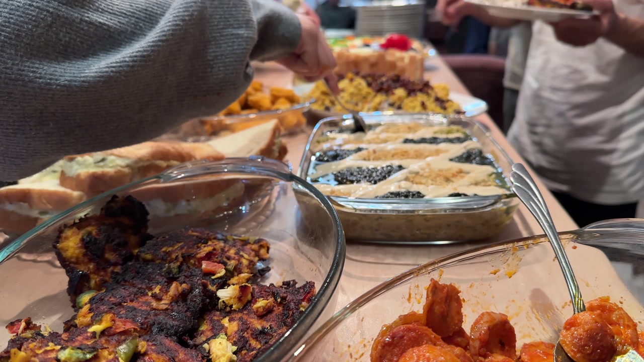 Persian party feast roasted eggplant kashke bademjan grilled sausages traditional stews and fresh vegetables Served buffet-style indoors for family gatherings with hot healthy meals sausage platter