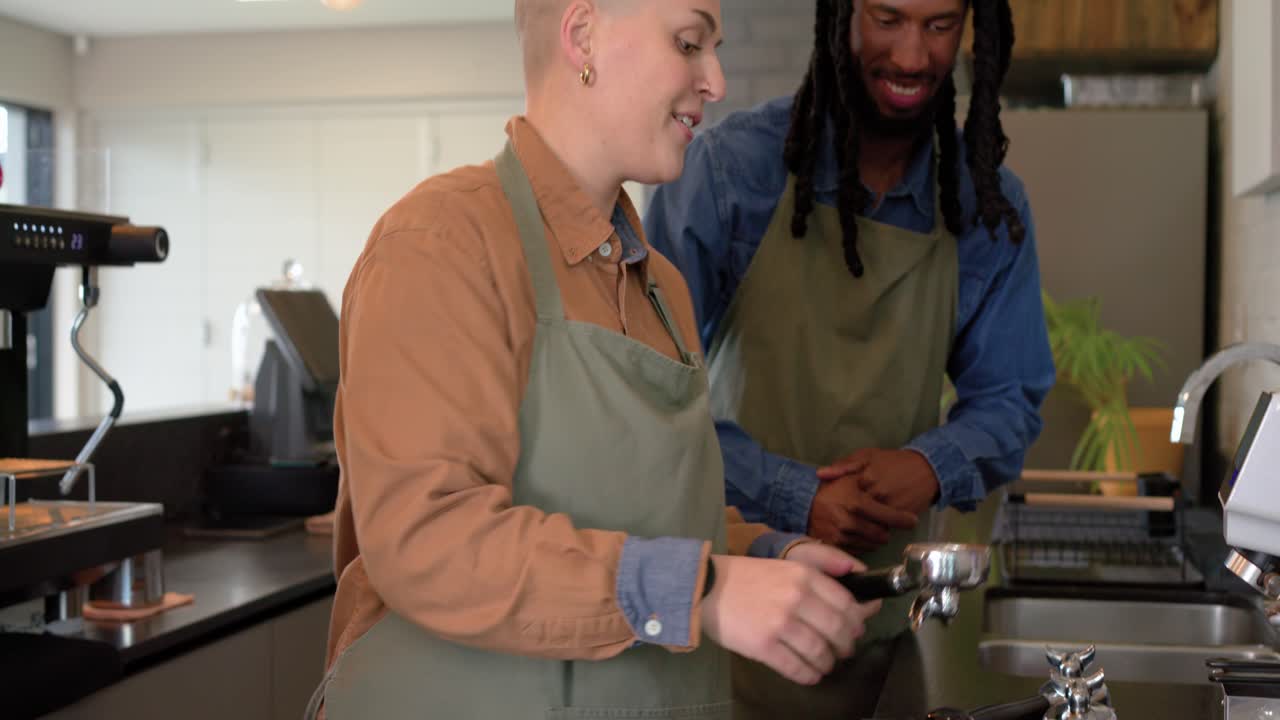 Una barista in formazione che riceve il pressino dall'istruttore, pesa sulla bilancia e prepara l'espresso al bancone.