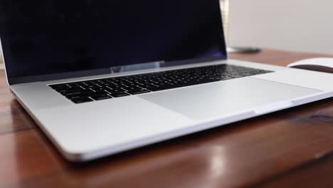 Slow-track-along-wooden-desk-top-with-laptop-and-mouse