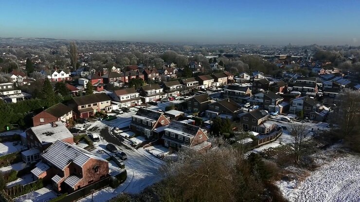 Veduta aerea in discesa verso un piccolo quartiere di un villaggio coperto di neve nel nord-ovest dell'Inghilterra