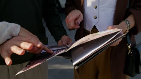 personas que revisan documentos al aire libre