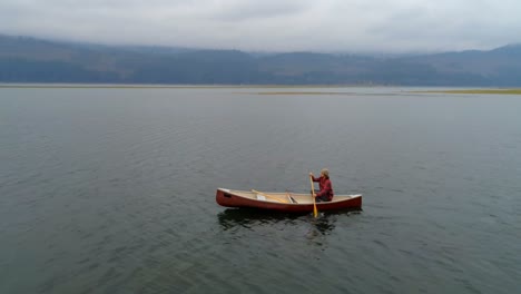 man rowing a boat on a lake 4k