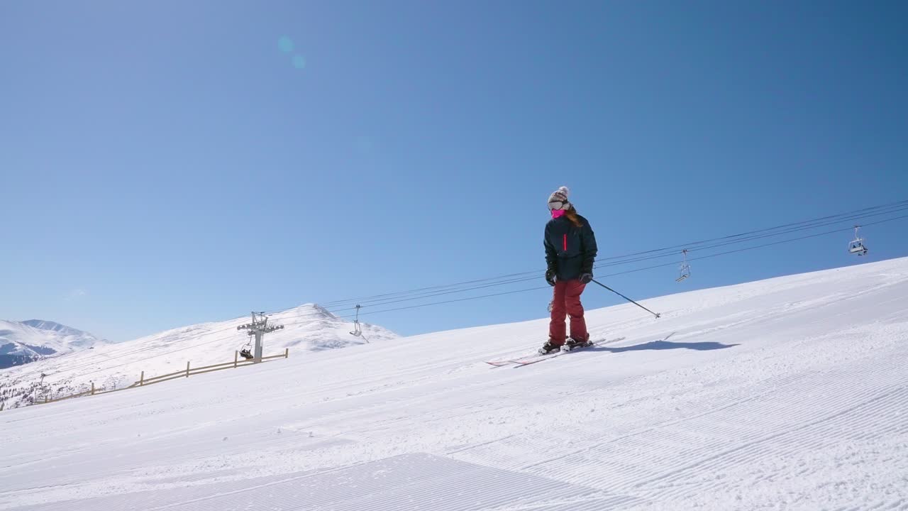 Downhill Skier Passing While Making a Turn on a Groomed Ski Run on the Mountainside