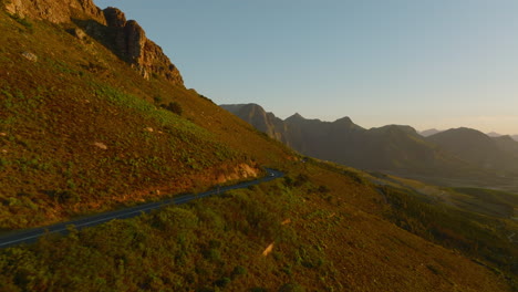 Filmaufnahmen-Einer-Straße,-Die-Um-Den-Bergrücken-Herumführt.-Erstaunliche-Abendaufnahme-Der-Landschaft-Bei-Sonnenuntergang.-Südafrika