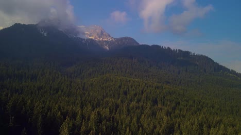 Eine-Drohne-Steigt-über-Den-üppigen-Wald-Auf,-Zoomt-In-Richtung-Des-Berggipfels-Und-Erzeugt-Eine-Visuell-Fesselnde-Und-Malerische-Aussicht