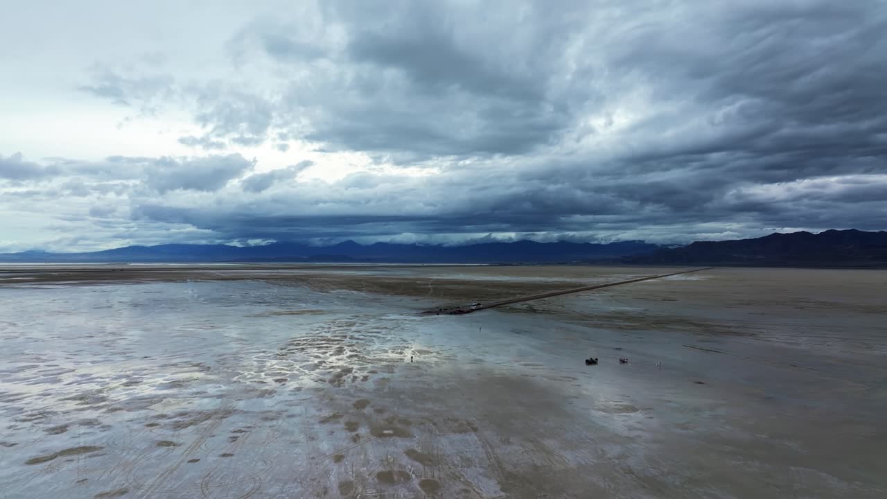 Extreme wide aerial drone descending shot of the beautiful tourist destination Bonneville Salt Flats in Utah near Wendover Nevada on a stormy spring evening with patches of wet and dry spots from rain