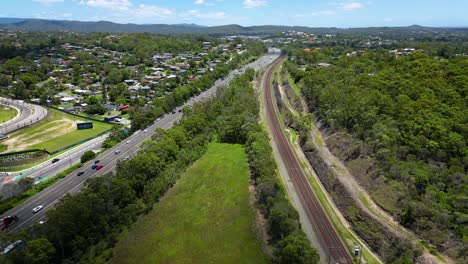 Vista-Aérea-Inversa-Sobre-Worongary,-M1-Y-Línea-Ferroviaria-Cerca-Del-Desarrollo-Skyridge,-Gold-Coast,-Queensland,-Australia