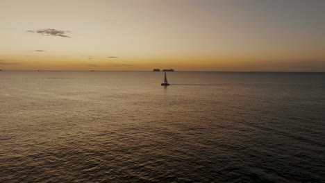 velero en el océano al atardecer en guanacaste, costa rica - toma aérea de drones