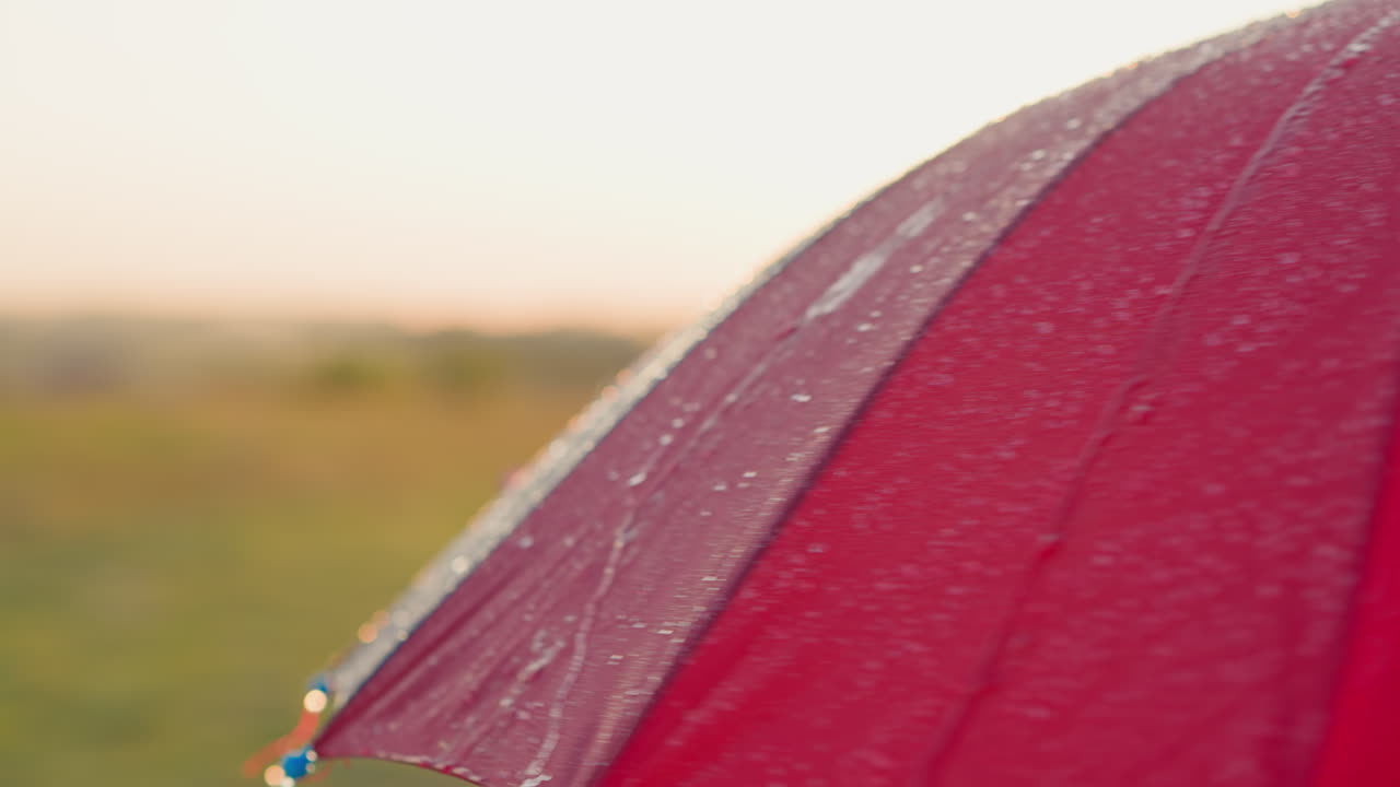방울의 물방울이 우산의 가장자리에서 떨어지고, 은 물은 무지개 에서 떨어집니다.