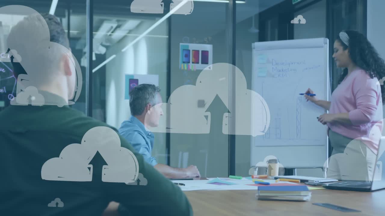 클라우드 업로드 아이콘의 애니메이션이 사무실에서 프레젠테이션을 하는 두 인종 여성에 대해 떠다니고 있습니다.