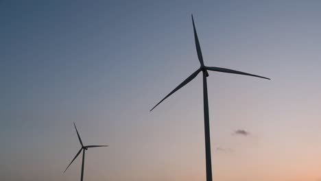 wind turbines silhouette against the blue-sky during sunset, clean alternative energy in thailand and mainland southeast asia