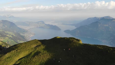 Sobrevuelo-Aéreo-Junto-A-Niederbauen-Chulm-En-Uri,-Suiza,-Con-Vistas-A-Las-Vacas-Pastando-Y-Los-Altos-Acantilados-Del-Pico-De-La-Montaña-Sobre-El-Lago-De-Lucerna-En-Una-Mañana-De-Verano-En-Los-Alpes-Suizos