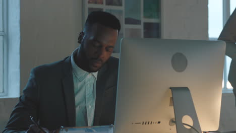 black man, night and office for writing in book